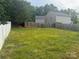 Large backyard with a mix of grass and trees and a white fence running along the side of the property at 3627 Alexander Forest Dr, Charlotte, NC 28269