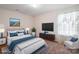A bright bedroom showcases a plush bed, a modern TV, and a comfortable armchair at 3627 Alexander Forest Dr, Charlotte, NC 28269