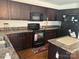 Kitchen featuring stainless steel appliances, an island, and dark wood cabinets at 3627 Alexander Forest Dr, Charlotte, NC 28269
