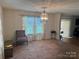 Bright and spacious living room with large window and decorative chandelier at 3627 Alexander Forest Dr, Charlotte, NC 28269
