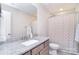 Clean bathroom features a light countertop, stainless steel fixtures, and a white and grey shower curtain at 4017 Avis Way, Monroe, NC 28110