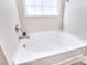 Bright bathroom features a soaking tub under a window, perfect for relaxation at 4017 Avis Way, Monroe, NC 28110