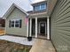 Inviting home with olive siding, covered porch, white columns, and American flag at 4017 Avis Way, Monroe, NC 28110