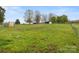 Wide open grassy field with a house, sheds, and a rusty shipping container at 5622 S Rocky River Rd, Monroe, NC 28112