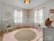 Charming Bedroom with soft pink accents, a rocking chair, and a cozy crib at 5622 S Rocky River Rd, Monroe, NC 28112