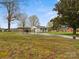 Exterior view of a white home with a large yard and a carport at 5622 S Rocky River Rd, Monroe, NC 28112