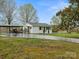 Exterior view of a white home with a large yard and a carport at 5622 S Rocky River Rd, Monroe, NC 28112