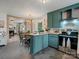 Open kitchen with teal cabinets, butcher block countertops, and access to a cozy living area at 5622 S Rocky River Rd, Monroe, NC 28112