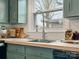 Butcher block countertops, teal cabinets, and a stainless steel faucet under a bright window define this kitchen sink area at 5622 S Rocky River Rd, Monroe, NC 28112