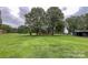 Sprawling backyard lawn features a serene green landscape, complemented by mature shade trees at 5622 S Rocky River Rd, Monroe, NC 28112