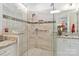 Modern bathroom featuring glass enclosed shower with tile surround, granite vanity with sink and white cabinets at 7336 Overjoyed Xing, Charlotte, NC 28215