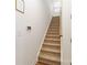 Carpeted staircase with wooden handrail and white walls, leading to the upper level of the home at 7336 Overjoyed Xing, Charlotte, NC 28215