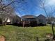 Backyard featuring a well-maintained lawn, deck, and privacy fence at 7700 Sedgebrook E Dr, Stanley, NC 28164