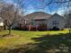 Spacious backyard featuring a wooden deck, green grass, and a charming exterior at 7700 Sedgebrook E Dr, Stanley, NC 28164
