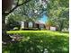 Lovely brick home on a lush green lawn with mature trees, well-manicured shrubbery, and a side entry garage at 7700 Sedgebrook E Dr, Stanley, NC 28164