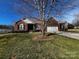 Charming single-story red brick home with a well-manicured lawn and an attached two-car garage at 7700 Sedgebrook E Dr, Stanley, NC 28164