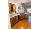 Open kitchen view with wooden cabinets, granite countertops, stainless appliances and hardwood floors at 7700 Sedgebrook E Dr, Stanley, NC 28164