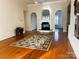Cozy living room featuring hardwood floors, fireplace, and archways leading to other rooms at 7700 Sedgebrook E Dr, Stanley, NC 28164