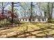 Charming one-story home featuring a brick facade, blue shutters, a well-manicured lawn, and mature trees in the yard at 800 River Oaks Ln, Charlotte, NC 28226
