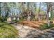 View of a one-story brick home surrounded by mature trees and landscaping, with a driveway leading to the street at 800 River Oaks Ln, Charlotte, NC 28226