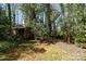 Backyard shed nestled among trees in a private, partially wooded backyard offering practical storage at 800 River Oaks Ln, Charlotte, NC 28226