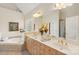 Well-lit bathroom with double sinks, large mirror, bathtub, and tiled floors at 820 Hampshire Hill Rd # 106, Matthews, NC 28105