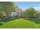 Beautifully landscaped front yard with lush green lawn and mature trees surrounding the brick home at 820 Hampshire Hill Rd # 106, Matthews, NC 28105