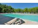 Large community pool with lounge chairs and surrounding trees at 820 Hampshire Hill Rd # 106, Matthews, NC 28105