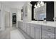 A luxurious bathroom has dual sinks and a vanity against black and white striped walls at 9332 Whistling Straits Dr, Fort Mill, SC 29707