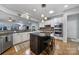 Spacious kitchen featuring an island with seating, stainless steel appliances, and tile backsplash at 9332 Whistling Straits Dr, Fort Mill, SC 29707