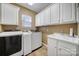 Functional laundry room with washer, dryer, sink and ample storage cabinets at 9332 Whistling Straits Dr, Fort Mill, SC 29707