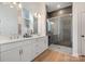 Modern bathroom with double vanity, a glass enclosed walk-in shower with a grey tile surround at 1113 Idyllic Ln, Waxhaw, NC 28173