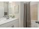 Bathroom featuring a white vanity with marble countertop, bathtub and a grey shower curtain at 1113 Idyllic Ln, Waxhaw, NC 28173