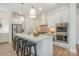 White kitchen features a large island with seating, stainless steel appliances, and pendant lighting at 1113 Idyllic Ln, Waxhaw, NC 28173