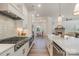 Elegant kitchen with stainless steel appliances, a range hood, and views to an adjacent living area at 1113 Idyllic Ln, Waxhaw, NC 28173