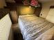 Comfortable camper bedroom with a queen-sized bed and overhead storage at 113 Cedar Ln, New London, NC 28127