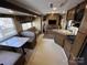 Camper interior with dinette seating, kitchen, and sofa for comfortable living at 113 Cedar Ln, New London, NC 28127