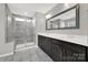 This bathroom features double sinks, dark cabinets, large mirrors and a tiled shower stall at 117 Stowe Rd, Belmont, NC 28012