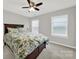 Bedroom with ceiling fan, floral comforter and plenty of natural light from the two windows at 117 Stowe Rd, Belmont, NC 28012