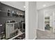 Well-equipped laundry room with modern washer and dryer units, adjacent to hallway and bathroom at 117 Stowe Rd, Belmont, NC 28012