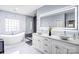 Luxurious bathroom featuring a freestanding tub, marble accents, a glass-enclosed shower, and a double vanity at 15818 Sparrowridge Ct, Charlotte, NC 28278