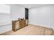Bright, minimalist bedroom with hardwood floors, modern trim, and a stylish accent cabinet at 15818 Sparrowridge Ct, Charlotte, NC 28278