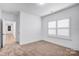 Bright bedroom featuring plush carpet, neutral walls, a window with shutters, and ample space at 15818 Sparrowridge Ct, Charlotte, NC 28278