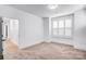 Simple bedroom with carpet, white walls and trim, and a large window with shutters at 15818 Sparrowridge Ct, Charlotte, NC 28278