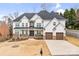 Elegant stucco home with a dark roof, two-car garage, stone accents, and manicured lawn at 15818 Sparrowridge Ct, Charlotte, NC 28278