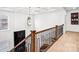 Staircase featuring wood and iron railings, complemented by coffered ceilings and a unique chandelier for an elegant entrance at 15818 Sparrowridge Ct, Charlotte, NC 28278