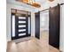 Stylish foyer with a modern front door, sliding barn doors, hardwood flooring, and wood beam accents at 15818 Sparrowridge Ct, Charlotte, NC 28278