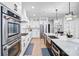 Bright modern kitchen with white cabinets, stainless steel appliances, and a large island with a sink at 15818 Sparrowridge Ct, Charlotte, NC 28278