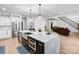 Bright open kitchen with island, stainless appliances, marble countertops, and views into the living room at 15818 Sparrowridge Ct, Charlotte, NC 28278