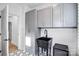Well-lit laundry room featuring gray cabinets, a black utility sink, and stylish hexagon tile flooring at 15818 Sparrowridge Ct, Charlotte, NC 28278